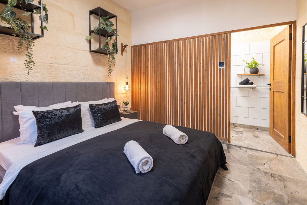 Queen-size bedroom with a sliding wooden door leading to the ensuite bathroom