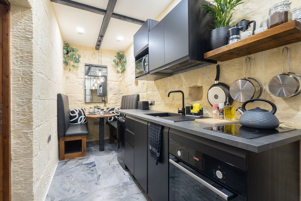 Fully equipped galley kitchen with exposed limestone walls at The Retreat