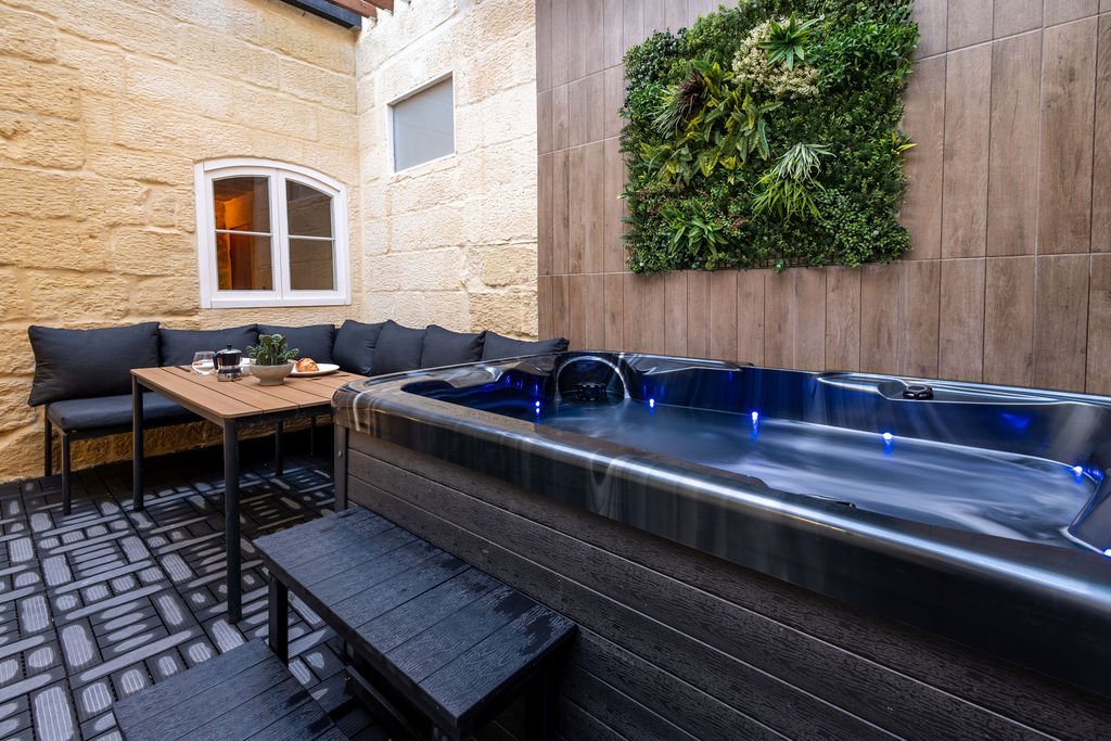 Hot tub beside the courtyard seating area at The Retreat in Gozo