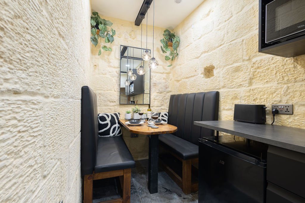 Compact kitchen and dining nook inside The Retreat in Gozo