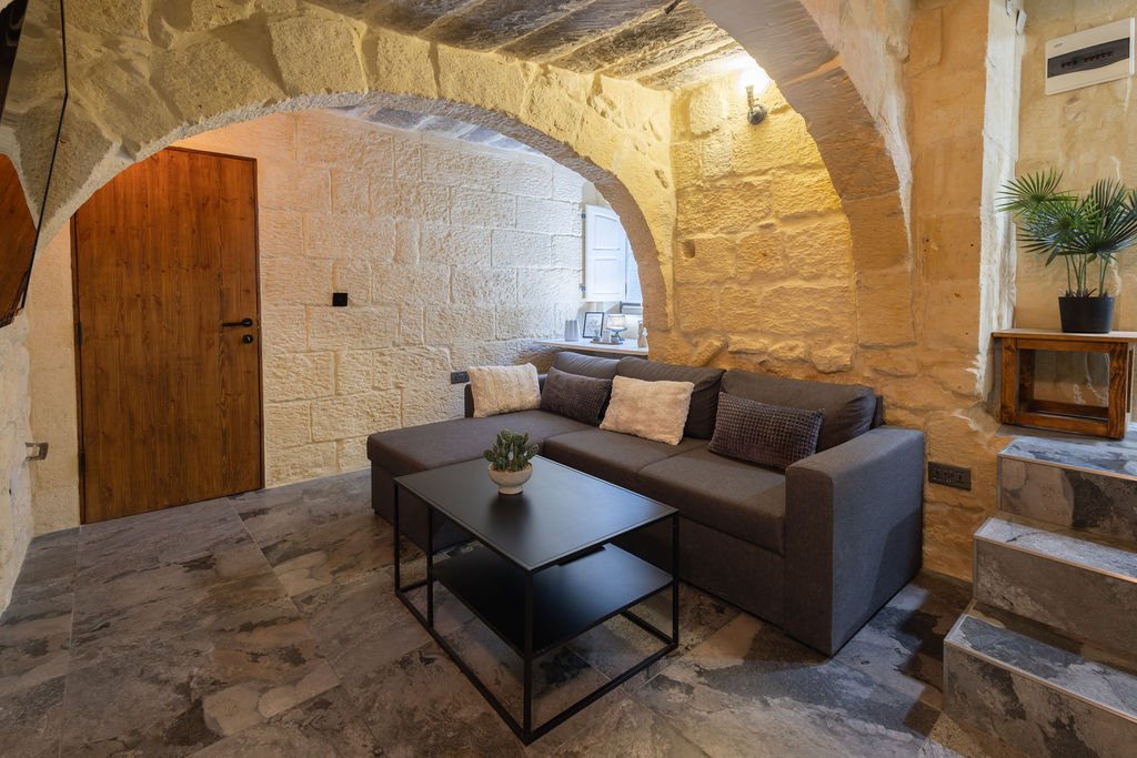 Living room framed by traditional Gozo limestone arches