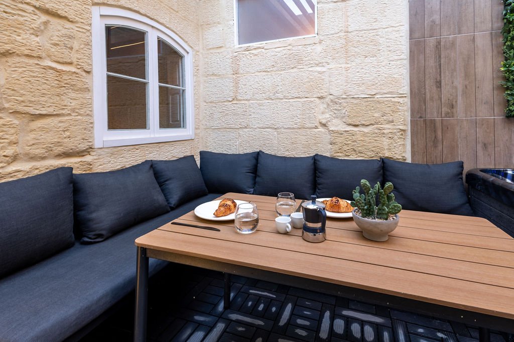Outdoor dining and lounge seating in the private stone courtyard